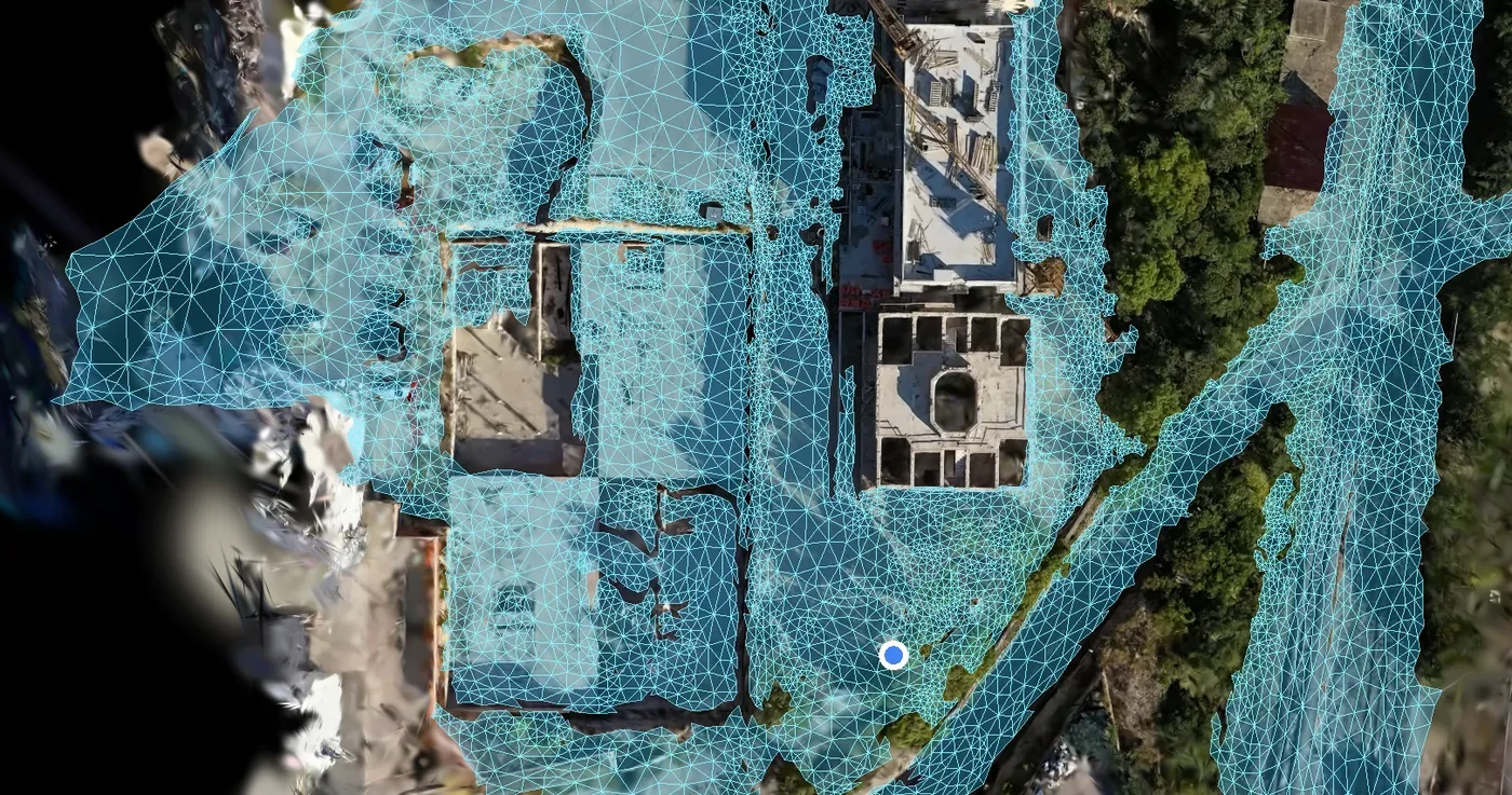Drone capture of a construction site with the derived walkable navigation graph drawn over it as a cyan triangle mesh
