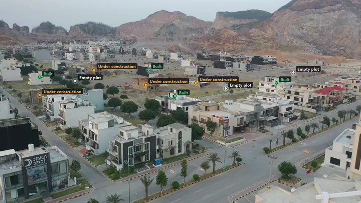 A housing society mapped from the air, every plot labelled built, under construction or empty