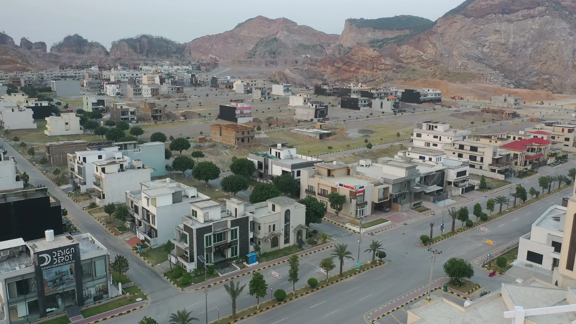 Drone view over a housing society with finished houses, houses being built and empty plots